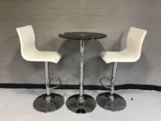 A glass top poser bar table and two hydraulic bar chairs