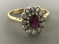 An 18ct gold ruby and diamond cluster ring, size N-O, 4.1g.