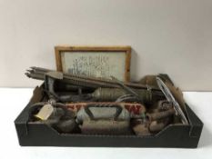 A box containing flat irons, vintage fire extinguishers, oil can,