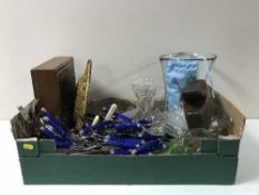 A box containing assorted glassware, brass wall plaques, table cutlery,