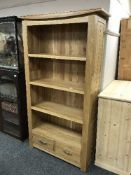A light oak open bookcase fitted with drawers
