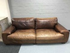 A pair of brown leather two seater settees with scatter cushions