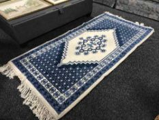 An ornate gilt framed mirror and a woollen rug
