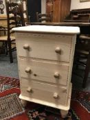 A light pine three drawer bedside chest