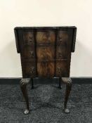 A shaped front walnut three drawer flap sided chest