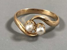An 18ct gold crossover ring set with two pearls, 2.