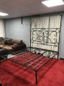 A wrought metal 6' bed frame with curtain