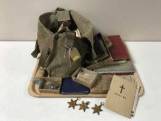 A tray of containing eight WWII medals with ribbons, cap badges, army prayer books,