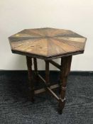 A Sri Lankan mixed wood folding occasional table bearing the name Ilson Carolis & Sons,