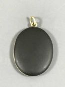 A large oval gold set memoriam locket, probably 14ct,