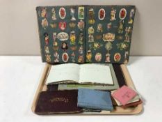 A tray containing early 20th century scrap book, autograph album, postcards,