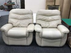 A pair of cream leather armchairs
