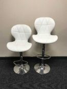 A pair of contemporary white leather gas lift bar stools