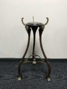 A mahogany tripod plant stand with brass feet and mounts