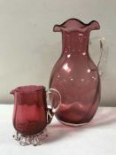 Two cranberry glass jugs