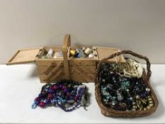 A concertina sewing box together with a basket containing a large quantity of assorted costume