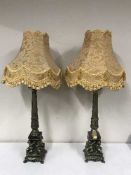 Two ornate metal and marble cherub column table lamps with shades