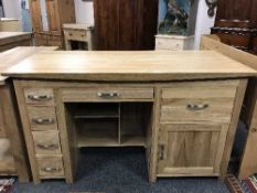 A contemporary light oak pedestal desk fitted with drawers