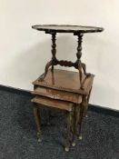 A nest of three glass topped tables and a walnut table