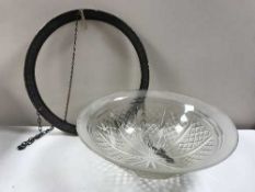 A circular glass hanging light fitting in a metal frame