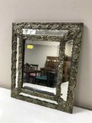 An antique brass framed cushion mirror