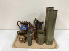 A tray of four brass ammunition shells and four copper lustre jugs
