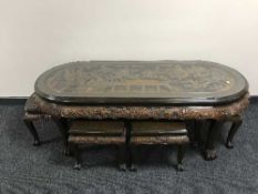 A large Oriental oval heavily carved glass topped coffee table depicting a battle scene,