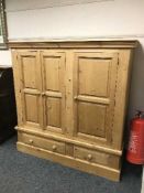 A pine child's triple door wardrobe fitted with drawers