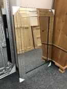 A contemporary all glass bevelled mirror