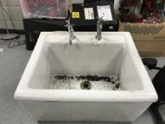 A large ceramic Belfast sink with taps