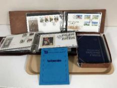 A tray of two albums of first day covers and a box of early 20th century coin collector's albums of