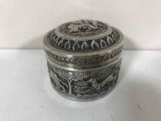 An Indian silver dressing table pot, embossed with scenes of tigers pursuing elephants and deer,
