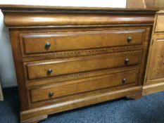 A contemporary four drawer chest in a walnut finish