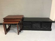 A nest of three stained pine tables and a low table with three wicker drawers