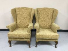 A pair of wing back armchairs in a gold fabric