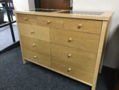 A contemporary nine drawer chest with two inset granite panels