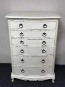 A cream bow-fronted six drawer chest