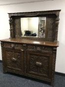 A Victorian Green Man heavily carved oak mirror backed sideboard