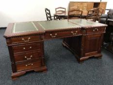 A reproduction twin pedestal partner's desk in set three green leather panels