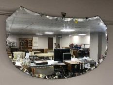 An un-framed mirror and a teak 1970's standard lamp