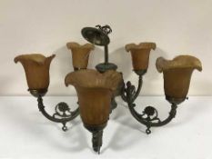 A five way brass chandelier with glass shades