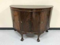 A mahogany d-shaped triple door sideboard on claw and ball feet