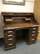An Edwardian oak roll topped desk