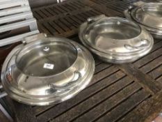 Seven stainless steel lidded serving dishes with warming stands