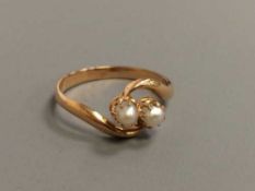 An 18ct gold crossover ring set with two pearls, 2.
