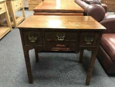 A Georgian walnut lowboy fitted with three drawers