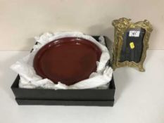 A brass Art Nouveau style photograph frame and a boxed oriental lacquer plate