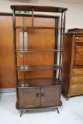 An Ercol elm open shelf room divider with a cupboard beneath CONDITION REPORT: