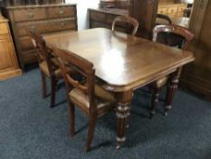 A Victorian mahogany wind out dining table with leaf and four odd chairs