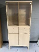 A contemporary beech glazed door cabinet